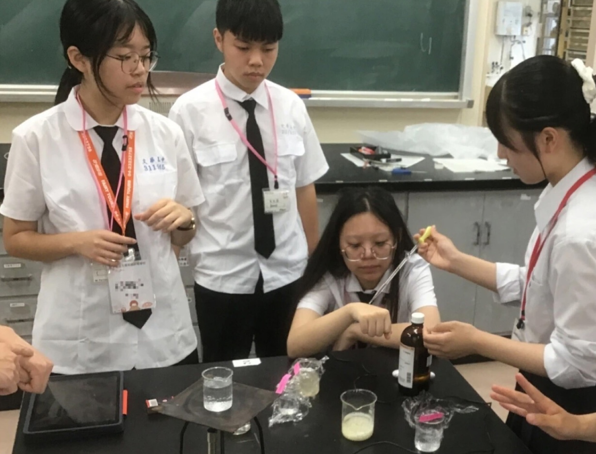 写真：体操服を着た小学生達が野原で虫取りをしている様子